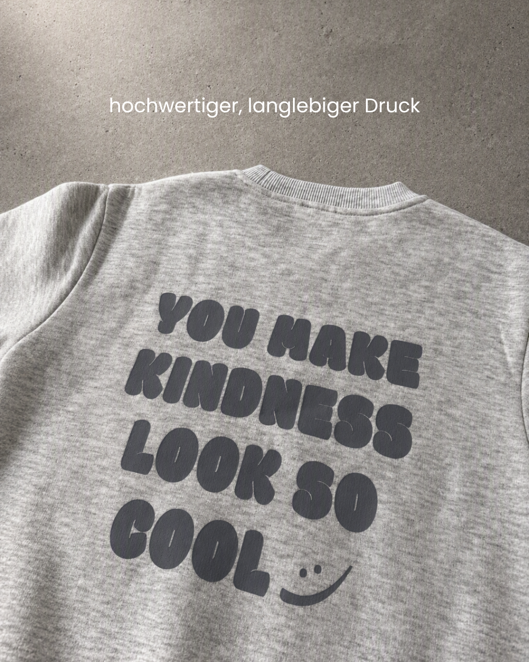 Nahaufnahme des Rückenprints You Make Kindness Look So Cool auf grauem Kinder-Sweatshirt von Comfy Studios
