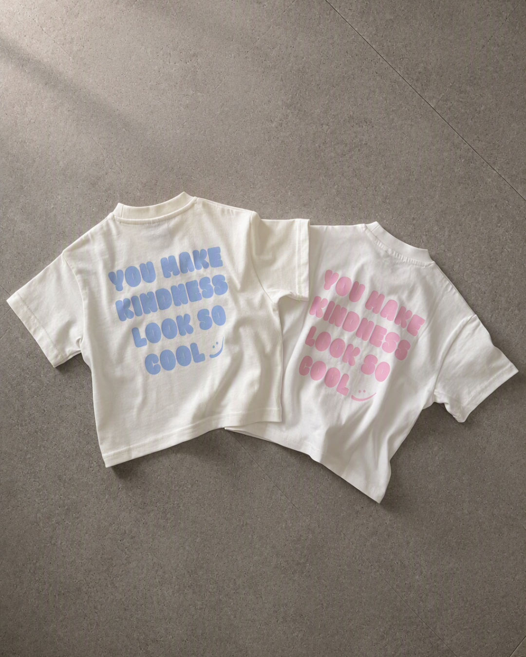 Kindess Shirt Blau und Rosa als Flatlay, Rückseite mit You make kindness Look so cool Print