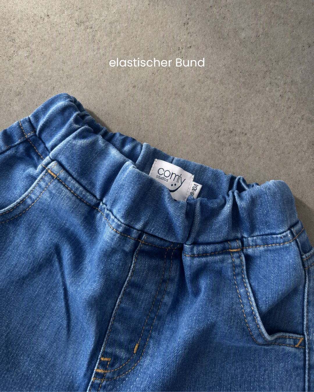 Nahaufnahme elastischer Komfortbund Comfy Studios Kinderjeans mit Label und Größe 98–104